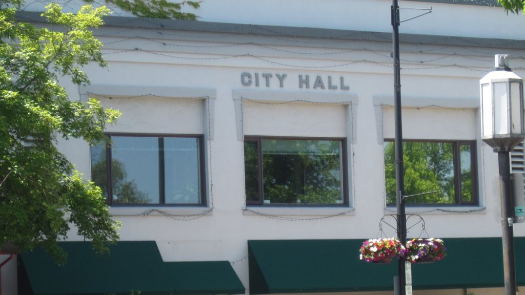 The white facade of Ashland City Hall with green awnings