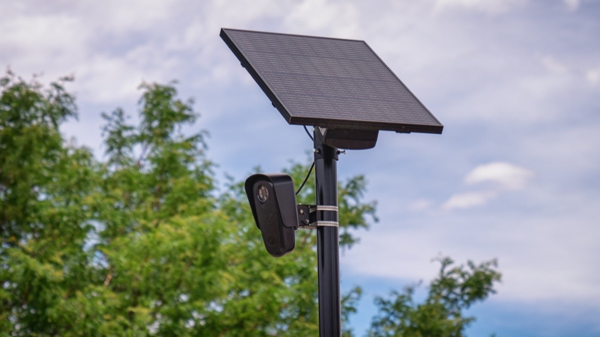 A pole-mounted Flock Safety license plate reader camera with a solar panel