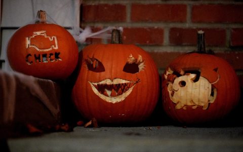 Three carved jack-o'-lanterns on a porch step